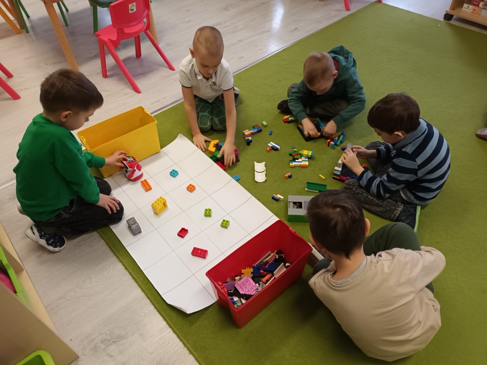 Dzień Lego - chłopcy budują z klocków lego, które zdobyli programując robota Doc.