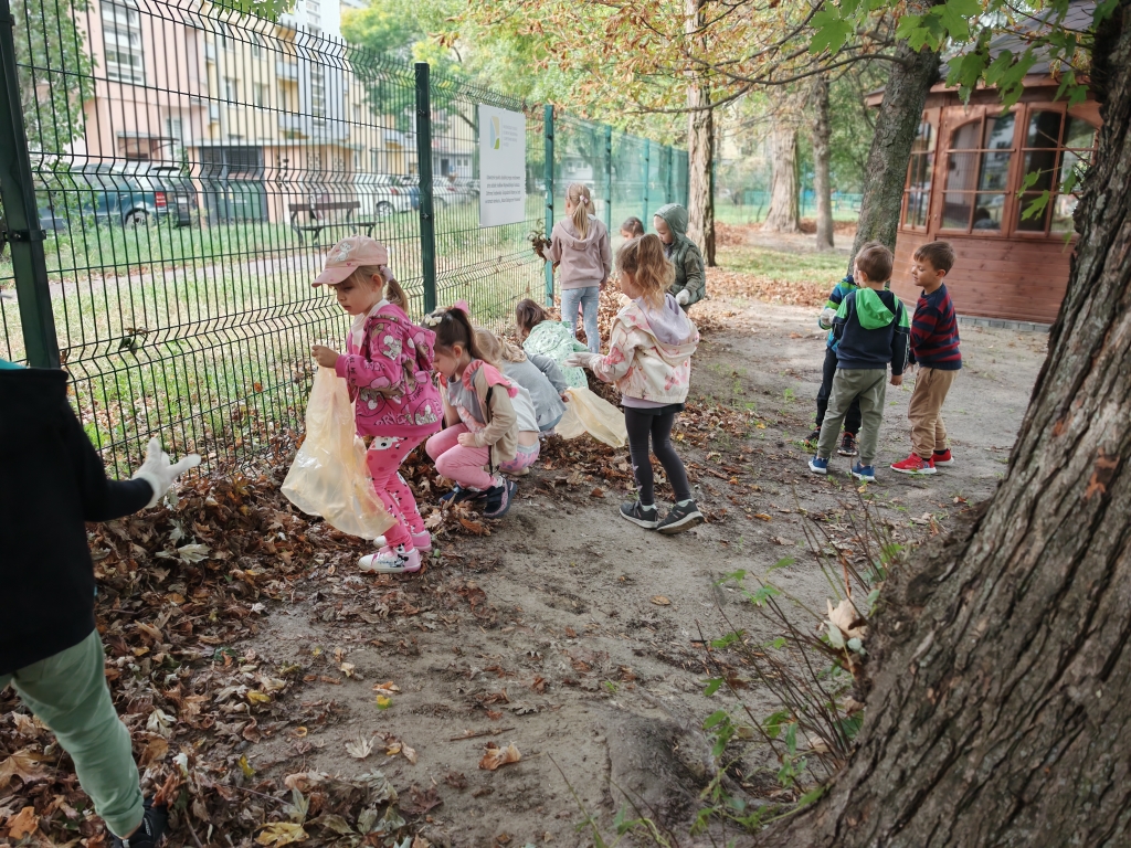 Sprzątanie świata - dzieci w rękawiczkach zbierają do worków śmieci