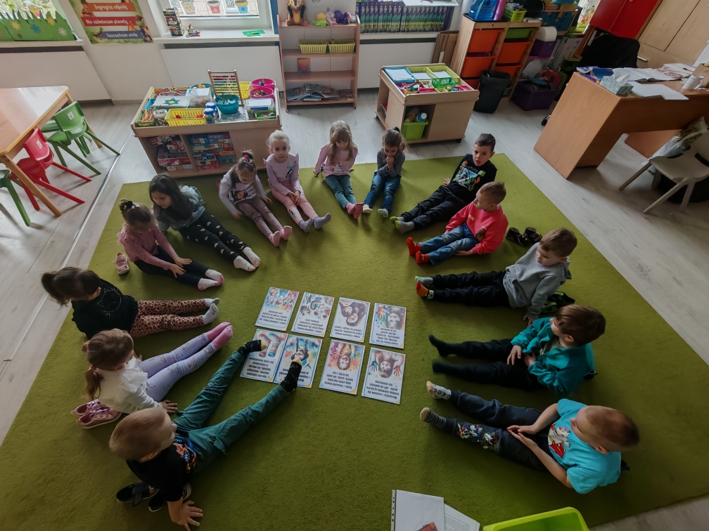 Dzień kolorowej skarpetki - dzieci siedzą w kole i prezentują swoje skarpetki.