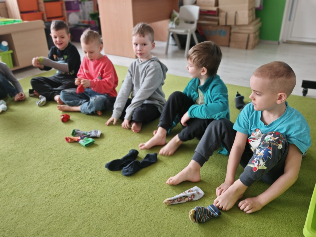 Dzień kolorowej skarpetki - dzieci siedząc w kole zdjęły skarpetki przygotowując się do kolejnej zabawy. 
