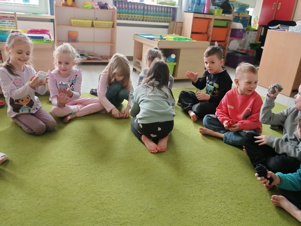 Dzień kolorowej skarpetki - dzieci zwijają swoje skarpetki w kulki.
