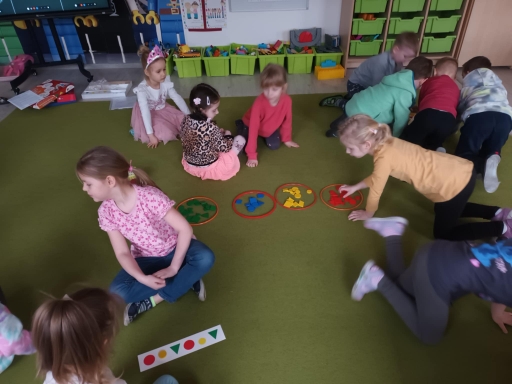 Dzień matematyki - dzieci siedzą w zespołach, każdy zespół układa rytm z figur według otrzymanego wzoru.