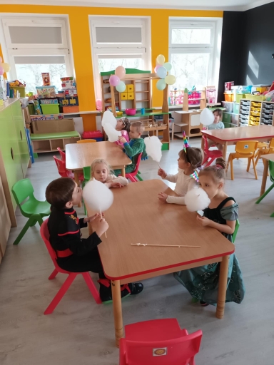 Bal - dzieci przy stolikach jedzą watę cukrową.