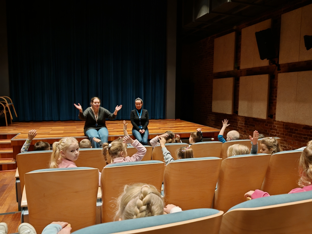 Wycieczka do Muzeum Kinematografii - Dzieci w kinie słuchają opowieści przewodniczki.