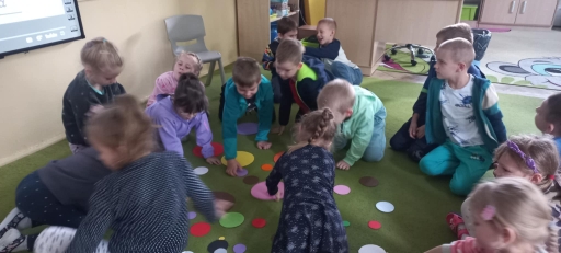 Dzień kropki - dzieci szukają kropek wymienionych przez nauczycielkę.