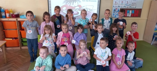 Spotkanie autorskie w bibliotece - zdjęcie grupowe dzieci prezentują okazjonalne medale.