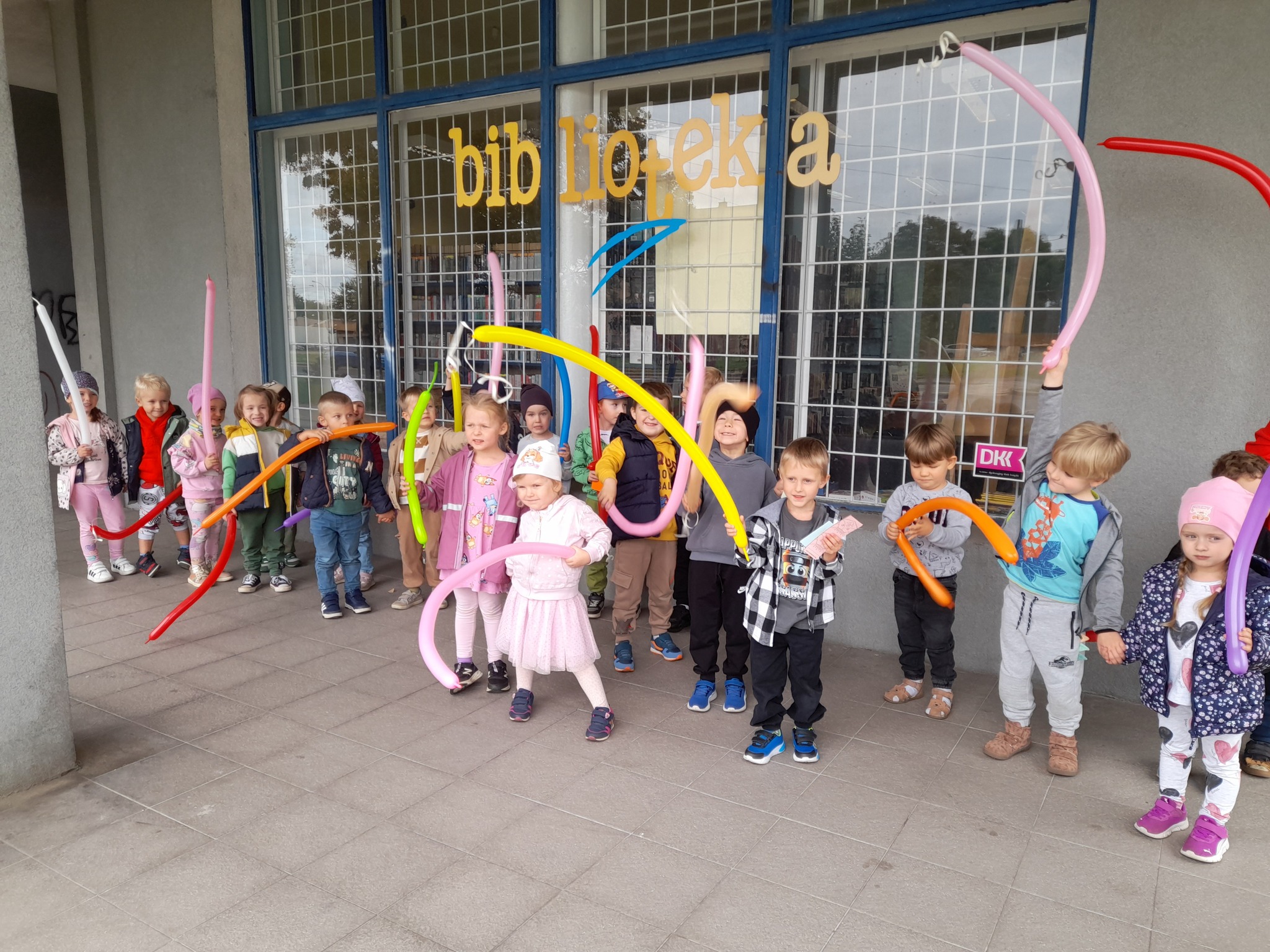 dzieci przed biblioteką z balonami 