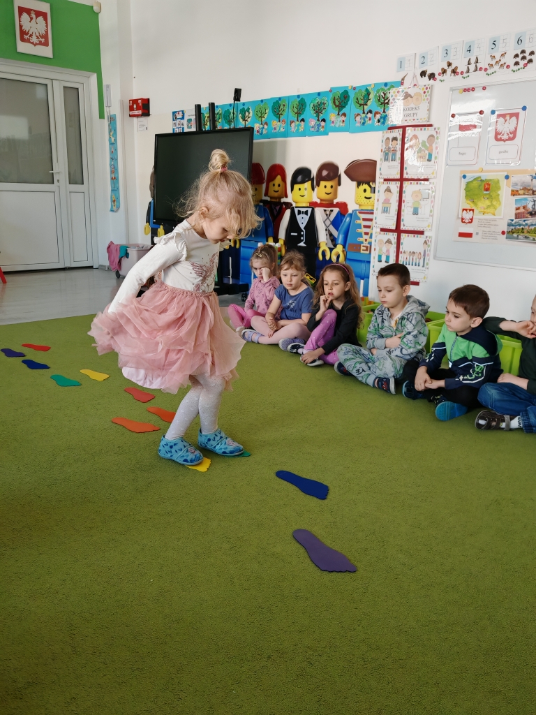 Projekt Działaj i liacz - dziewczynka pokonuje ścieżkę z kolorowych stópek.